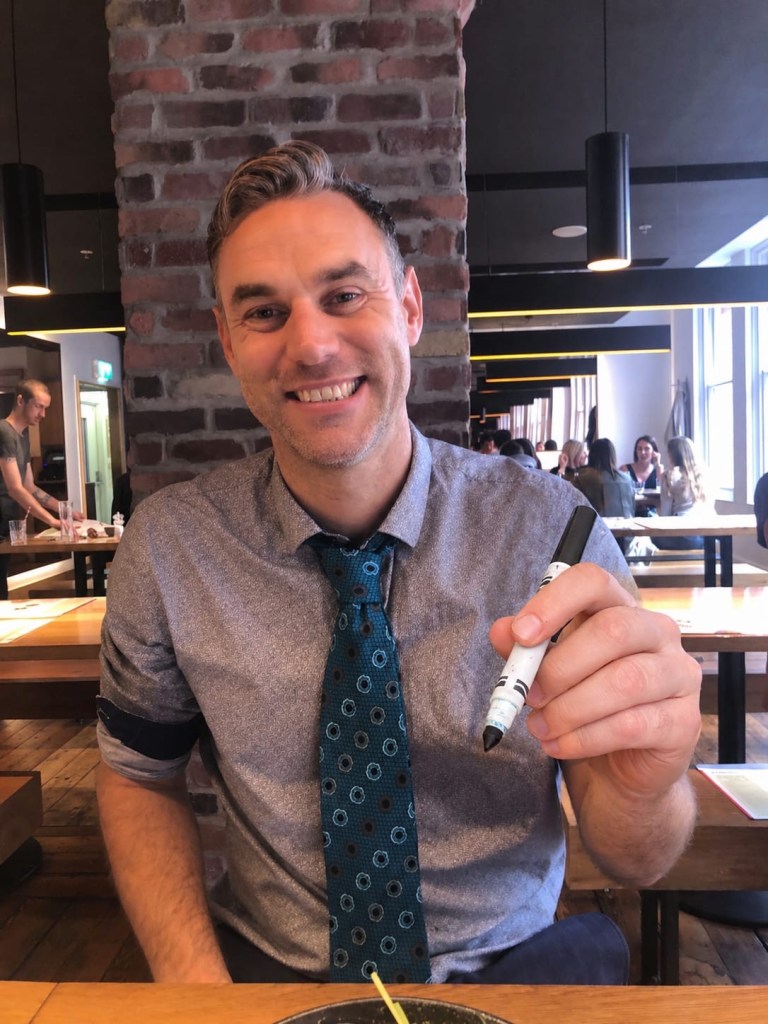 Andrew Goti holding a marker