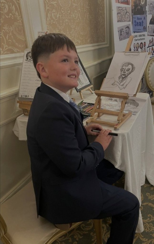 A young wedding guest drawing his own caricature of Andy at the Creative Corner